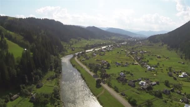 Hermoso valle con pueblo y río en las montañas. Disparo aéreo — Vídeos de Stock