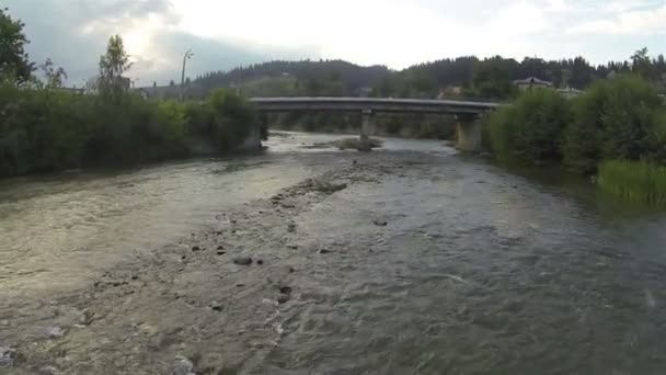 Över floden i berg uppgörelse. Antenn — Stockvideo