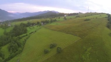 Dağ yamaçlar ağaçlar ve bulutlu gün köyde. Hava arka sinek
