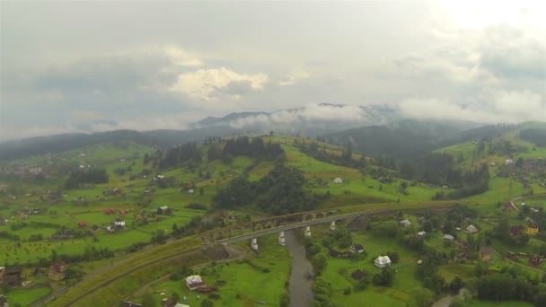 Lantliga bergsområden med by i molnig dag. Aerial panorama — Stockvideo