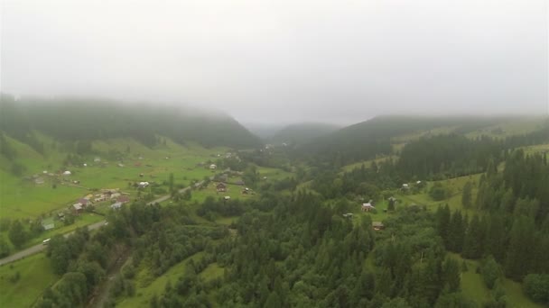 Vlucht over mist, bergen en dorp. Luchtfoto — Stockvideo