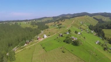 Uçuş üzerinde tepe Köyü ve ahşap ile dağlarda. Hava
