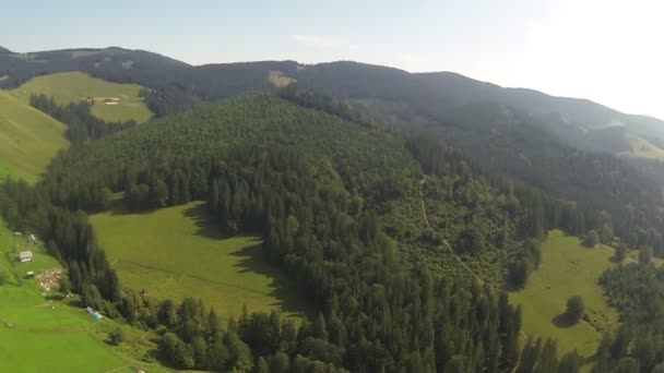 Flucht über kleine Berge mit Wald und Dorf. Luftpanorama — Stockvideo