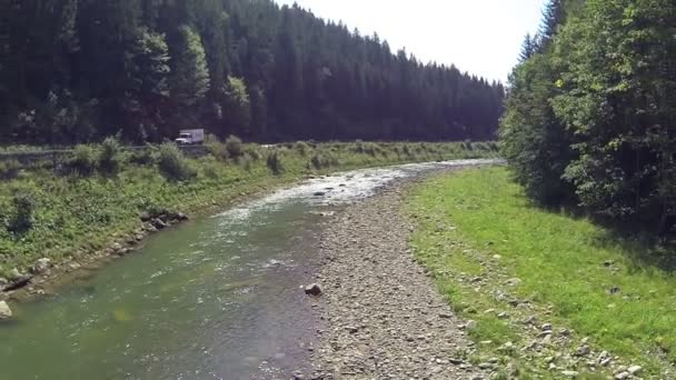 Vuelo trasero sobre el río con carretera y madera. Antena — Vídeos de Stock