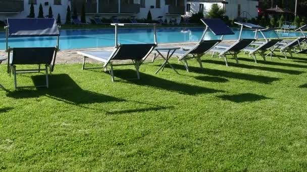 Panorama da piscina com bancos de fogão para descanso. Movimento vertical — Vídeo de Stock