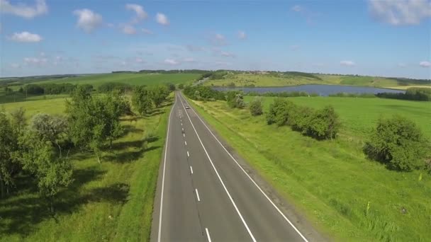 高速道路の車と丘の美しい湖。空中の 43 秒フライ — ストック動画