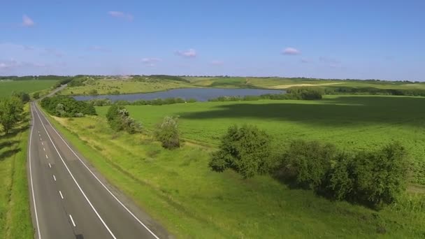 Carretera vacía. Paisaje aéreo con colinas y lago — Vídeo de stock