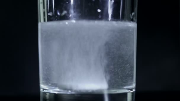 Tablette prickelndes Aspirin in Wasser auf schwarzem Hintergrund — Stockvideo