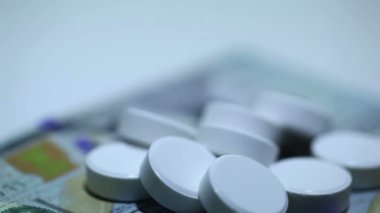 Tabletler ve para rotasyon beyaz zemin üzerine beyaz