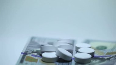 Tabletler ve para rotasyon beyaz zemin üzerine beyaz