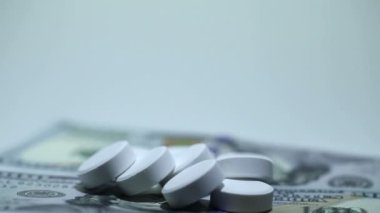 Tabletler ve para rotasyon beyaz arka plan üzerinde beyaz. Makro