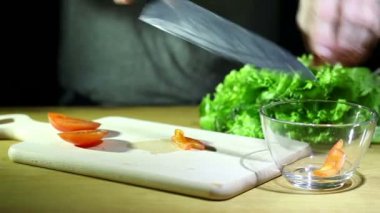 Adamın elleri üzerinde salata domates kes. Yakın çekim