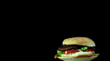 Hamburger rotasyon siyah arka plan üzerine kızarmış patates ile