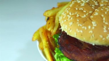 Hamburger rotasyon beyaz zemin üzerine kızarmış patates. Makro