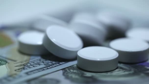 Weiße Tabletten und Geld in Rotation auf weißem Hintergrund. Makro — Stockvideo