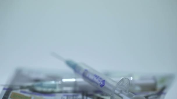 Medical syringes and money in rotation on  white background — Stock Video