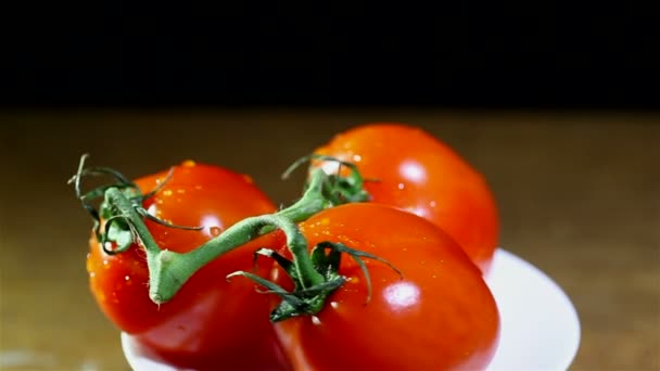 Drie rode tomaten draait op wit bord. Close-up — Stockvideo