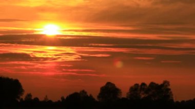 Parlak kırmızı bulutlar ve günbatımı. Zaman atlamalı