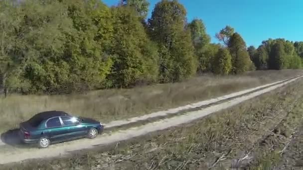 Coche verde solitario en el camino de tierra rural. Vista aérea — Vídeos de Stock