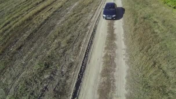 시골의 비포장도로에 외로운 녹색 자동차입니다. 공중 평면도 — 비디오