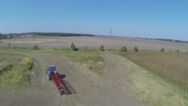 Полет за сельскохозяйственным трактором в поле. Воздушный — стоковое видео