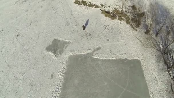 Silhouette of  going person on frozen lake. Aerial — Stock Video