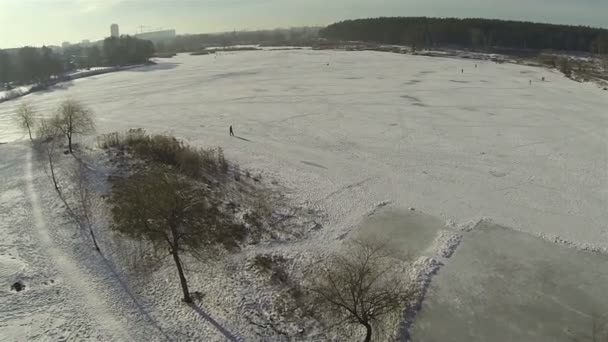 Зима, озеро, лед и силуэты людей. Пейзаж. Воздушный — стоковое видео