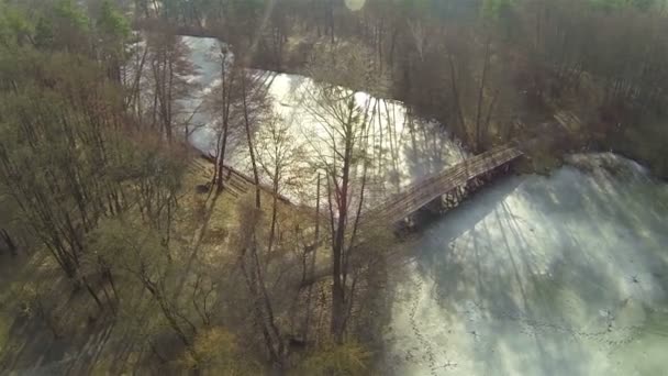 Pont en bois sur rivière gelée en bois. Aérien 