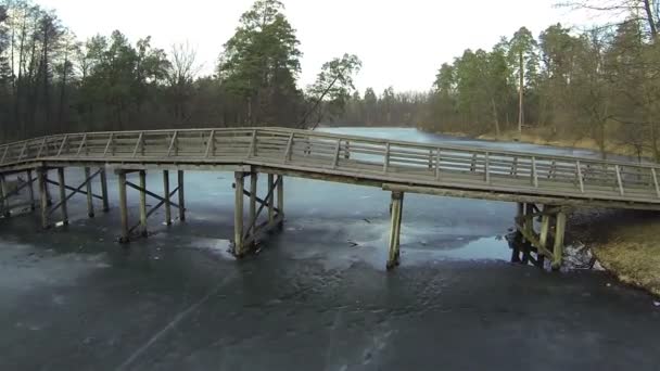 Puente de madera sobre el congelado río de invierno. Antena — Vídeo de stock