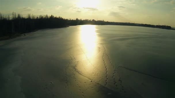 Solnedgang ved frossen sø. Antenne – Stock-video