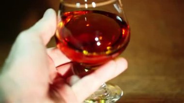 Adamın elinde bir bardak konyak, brandy yakın çekim