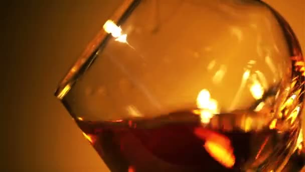 Cognac, whisky dans un verre fermé à la lumière rouge — Video