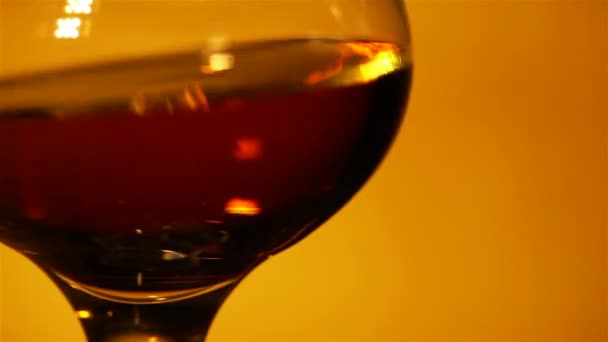 Cognac, whisky i ett glas på nära håll i rött ljus — Stockvideo