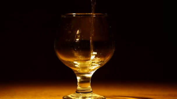 Gouden cognac, brandewijn wordt gegoten — Stockvideo