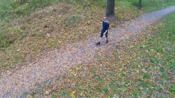 El hombre camina en el parque de otoño. Vista aérea — Vídeo de stock