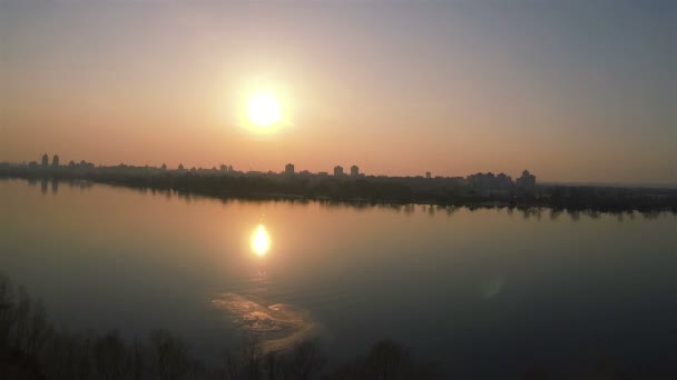 Vuelo lateral sobre el río con puesta de sol roja. Disparo aéreo — Vídeo de stock