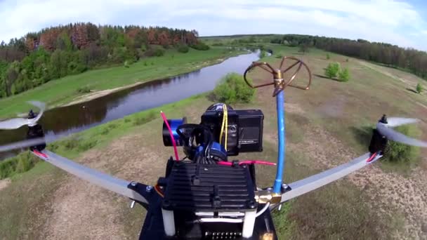 Flying drone with camera filming field with river . POV clip — Stock Video