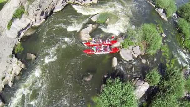 Toeristen per boot zitten op steen. Luchtfoto van rafting team — Stockvideo