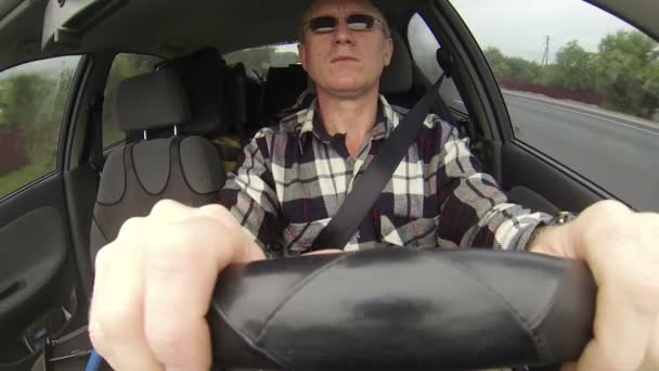 L'uomo con gli occhiali guida l'auto. Riprese in salone di auto, clip POV — Video Stock