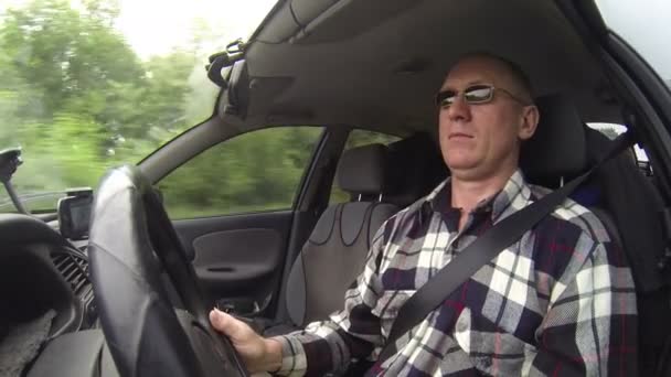Mann mit Brille fährt Auto. Schießerei im Autosalon, linke Seite — Stockvideo