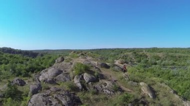 Kızın uzun yürüyüşe çıkan kimse siluet üzerinde dağda sinek. Havadan görünümü
