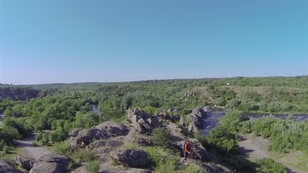 Voar ao redor menina caminhante na montanha com o sol. Vista aérea — Vídeo de Stock