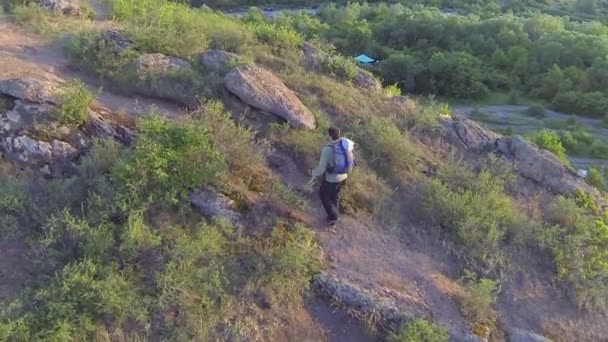 Volar alrededor de hombre excursionista turista caminando colina arriba. Antena — Vídeos de Stock