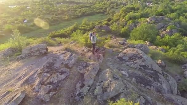 Fly вокруг человека турист стоя на вершине холма. Воздушный — стоковое видео