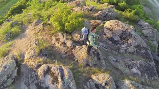 Langzame vliegen over man wandelaar toerist die zich op de heuveltop. Luchtfoto — Stockvideo