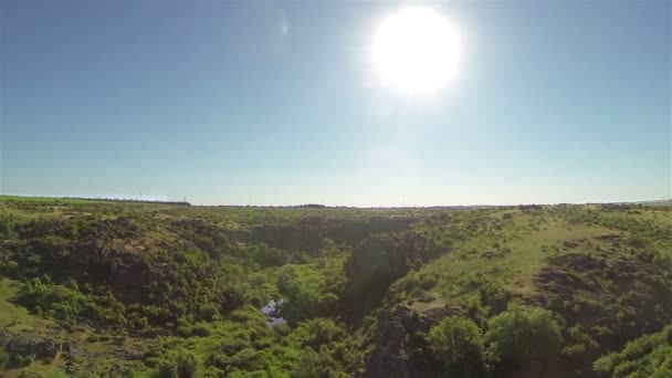 Vlieg boven zonnige canyon met bomen, rivier. Luchtfoto — Stockvideo