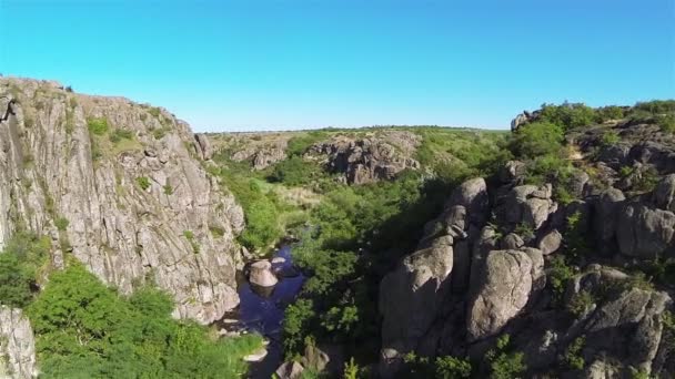 Прекрасні скелі в каньйоні з річкою. Повітряна низька висота — стокове відео