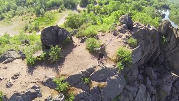 Turista mujer en pie de montaña con las manos levantadas. Antena — Vídeos de Stock