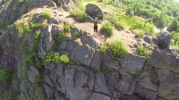 Turista mujer en pie de montaña con las manos levantadas. Antena — Vídeos de Stock