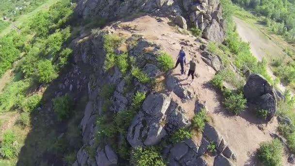 Una pareja de turistas en la cima de la montaña. Vista aérea — Vídeos de Stock